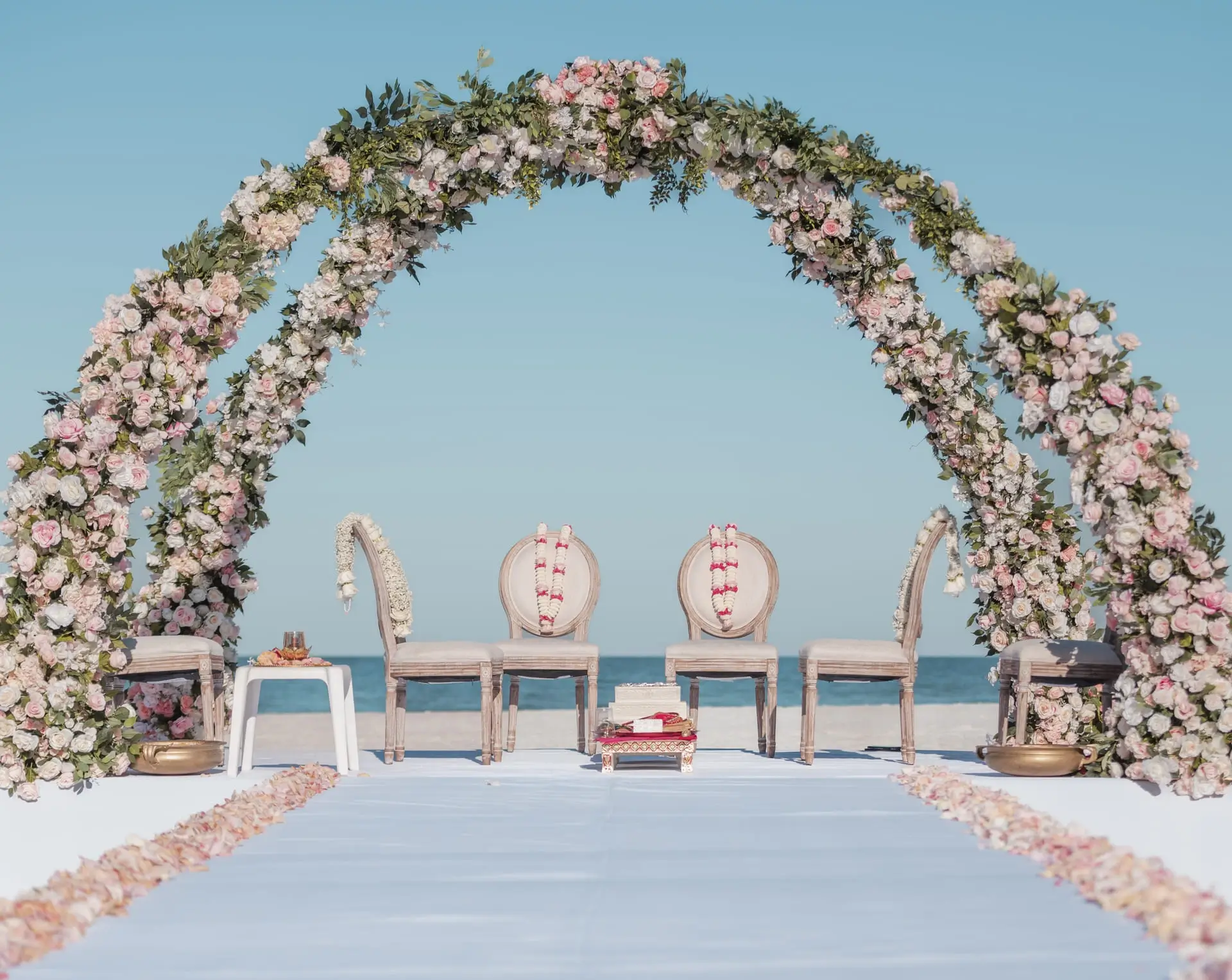 Outdoor ceremony framed by floral pillars and guests