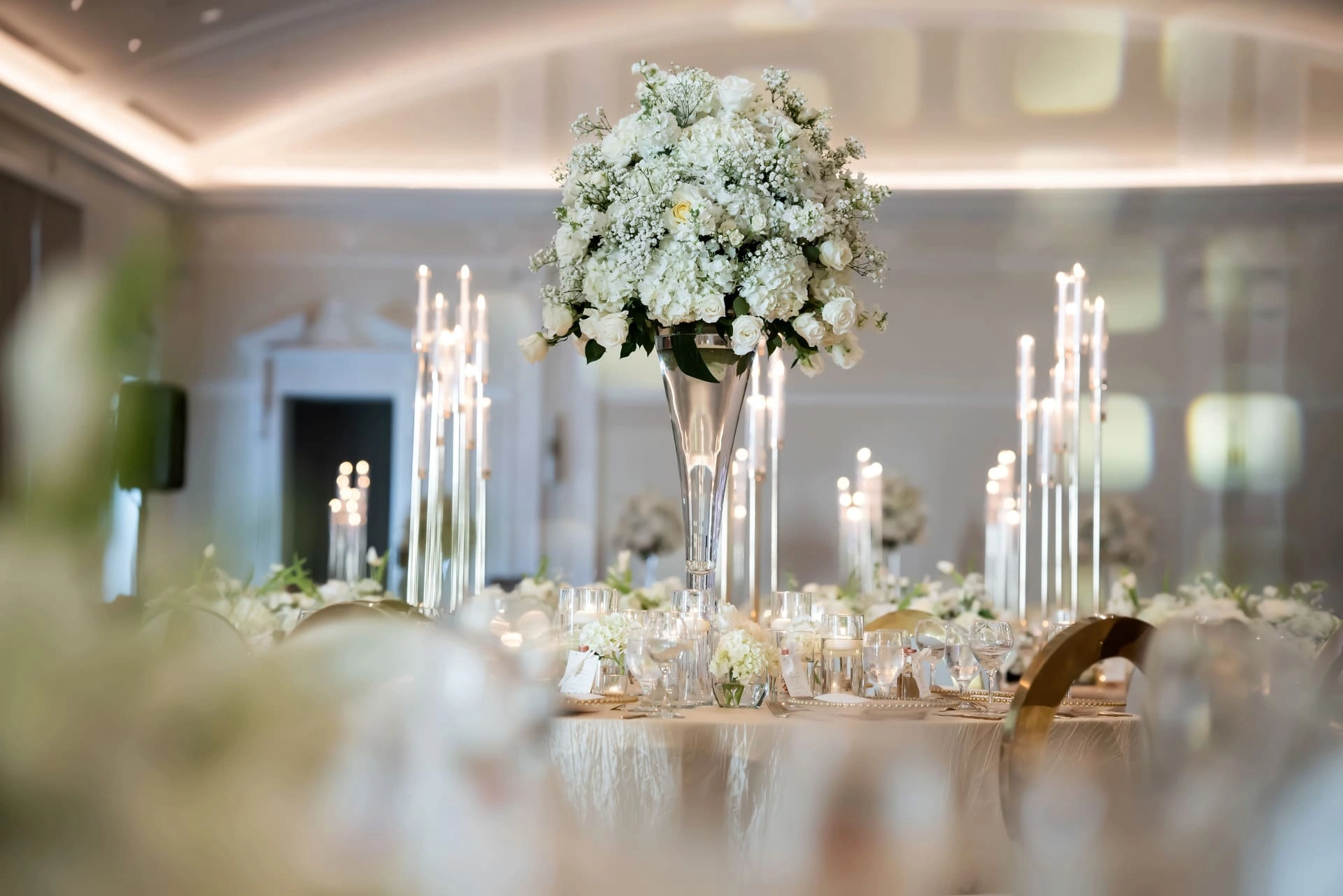 Candlelit dinner setting with blush florals and gold flatware